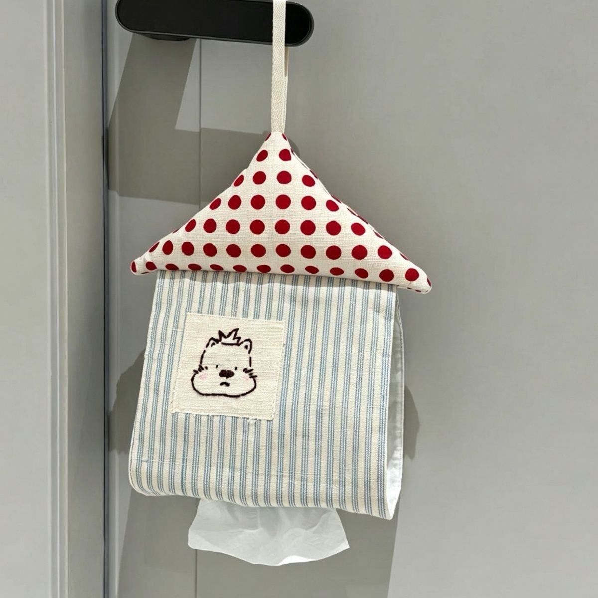 Blue-and-white striped hanging fabric tissue holder with a house-shaped design