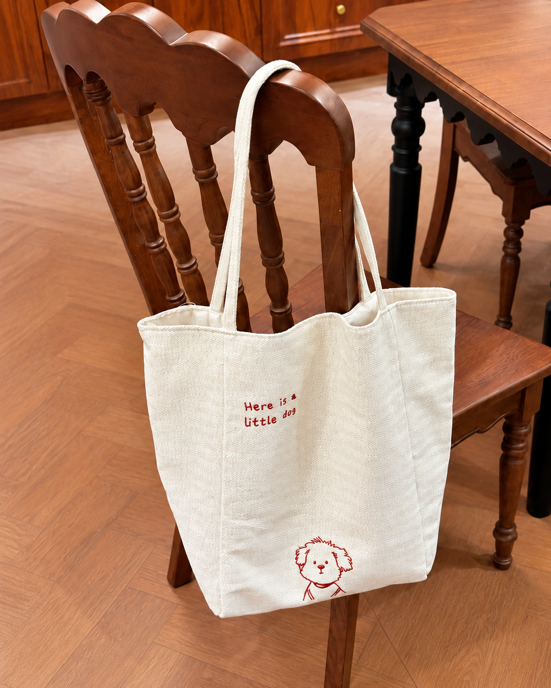 Dog embroidered tote bag displayed on a chair