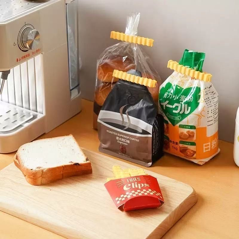 Yellow wavy bag clips closing pantry bags beside bread on a kitchen counter.