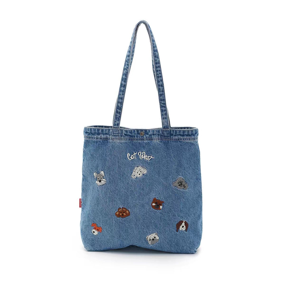 Front view of washed-blue denim tote bag with embroidered animal motifs