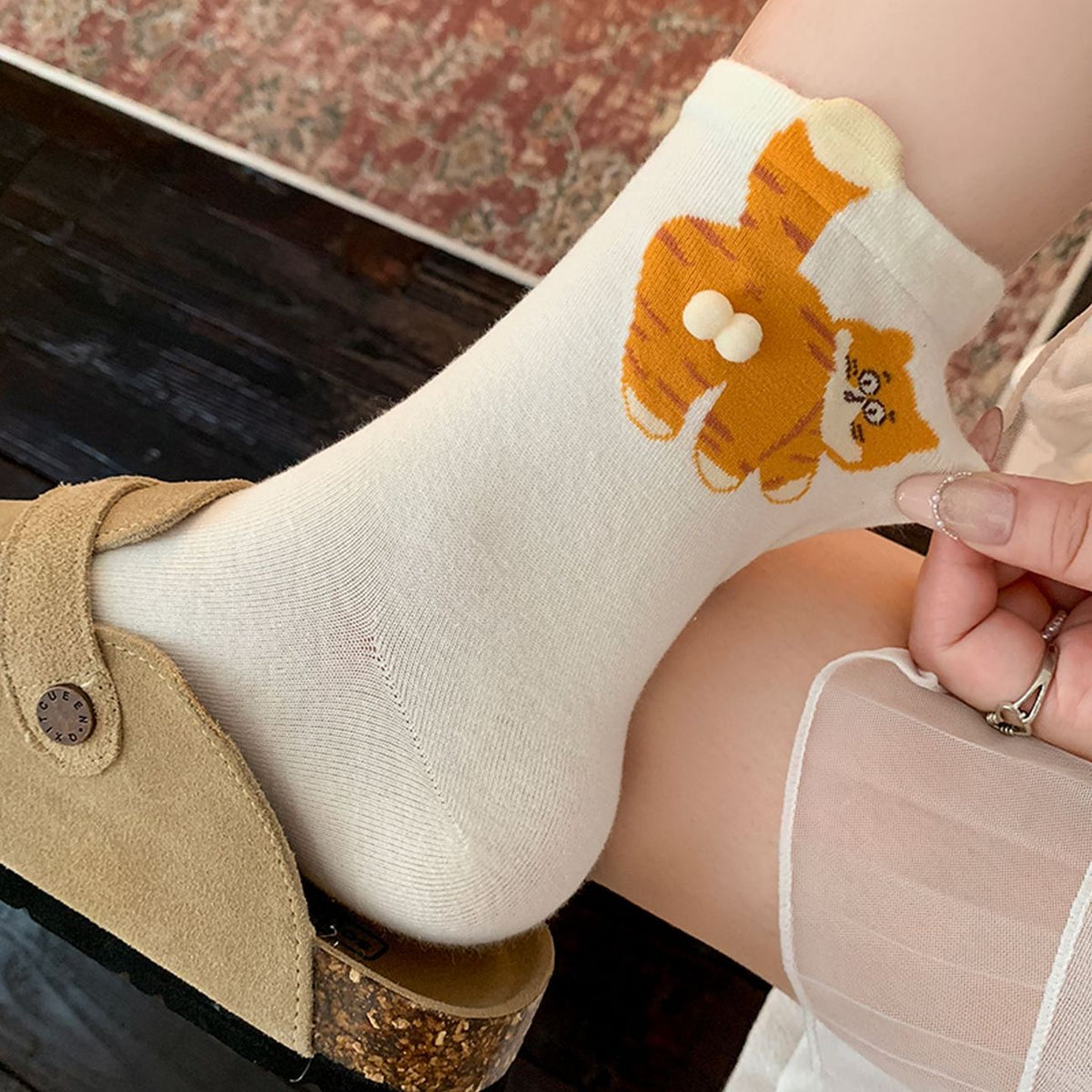 White cat patterned crew socks worn with casual shoes