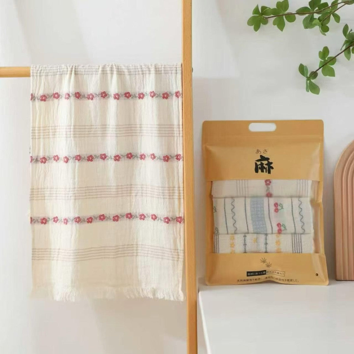 Floral striped gauze hand towel displayed with its kraft packaging