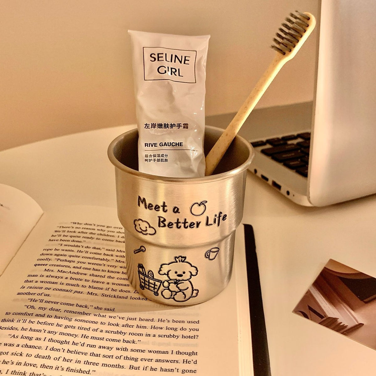 Silver tiered toothbrush cup with a toothbrush on a bathroom counter.